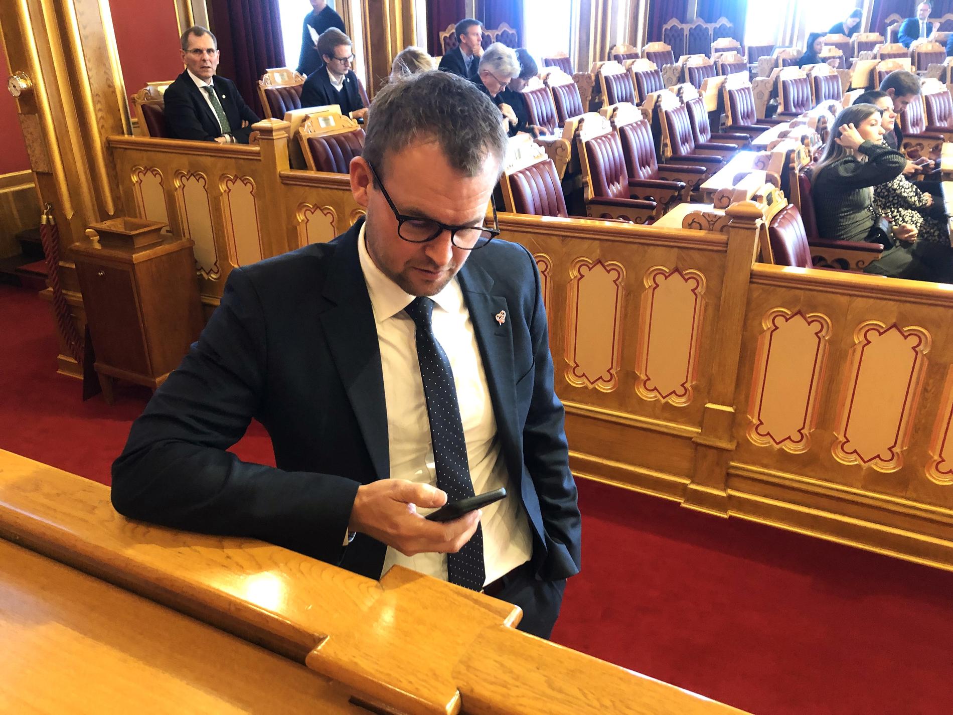 CELLULARE NELLA SALA DEL PARLAMENTO: Kjell Ingolf Ropstad (KrF) controlla il suo cellulare mentre si reca al suo posto nell'aula del Parlamento.
