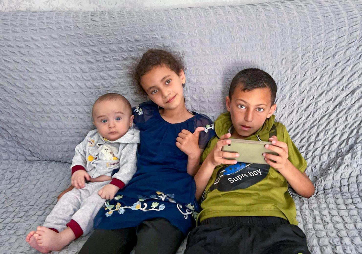Between the two brothers: Khadija (8) with her two brothers Elias (1) and Jawad (10). 