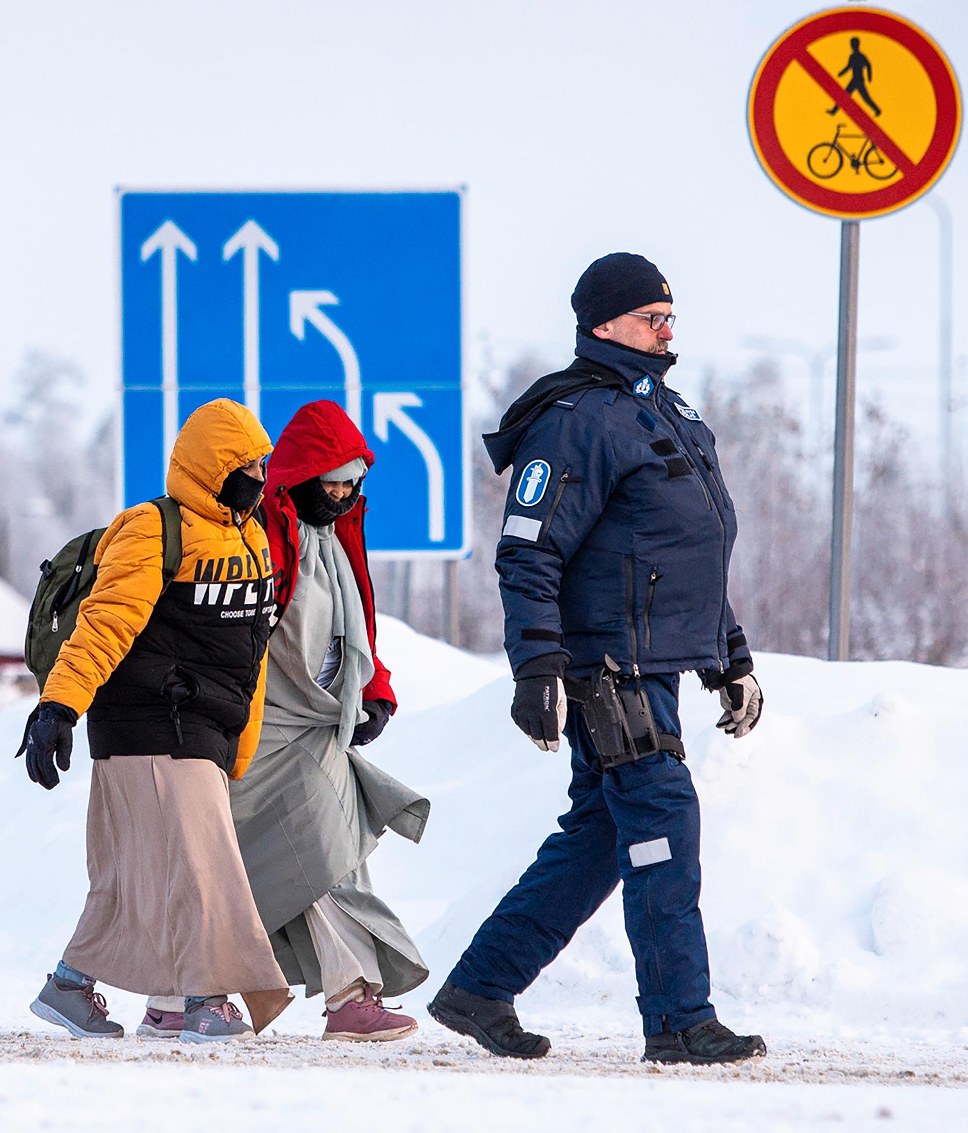 Border: On Tuesday, Finnish border police escorted refugees after they arrived at the Vartius crossing from Russia.