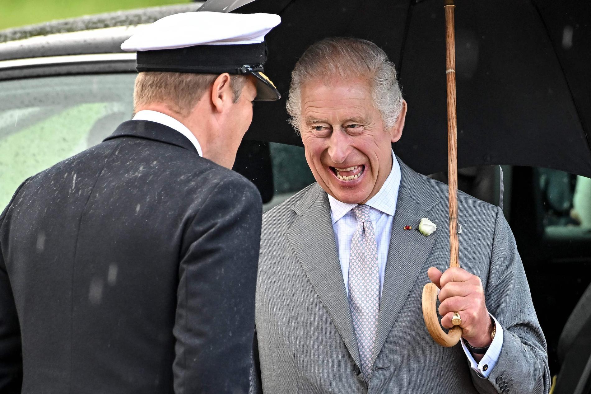 Cheerful: King Charles seems to have kept his spirits high despite the rain in Bordeaux.