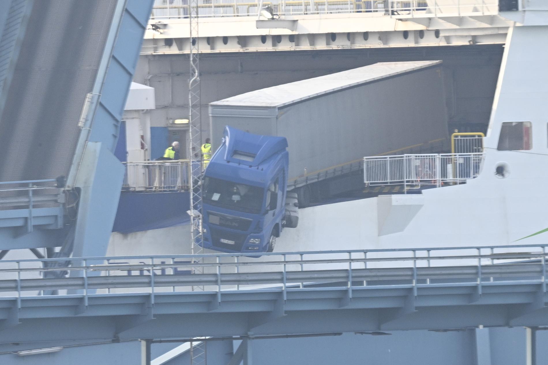 A truck hangs on the edge of a ferry in Sweden