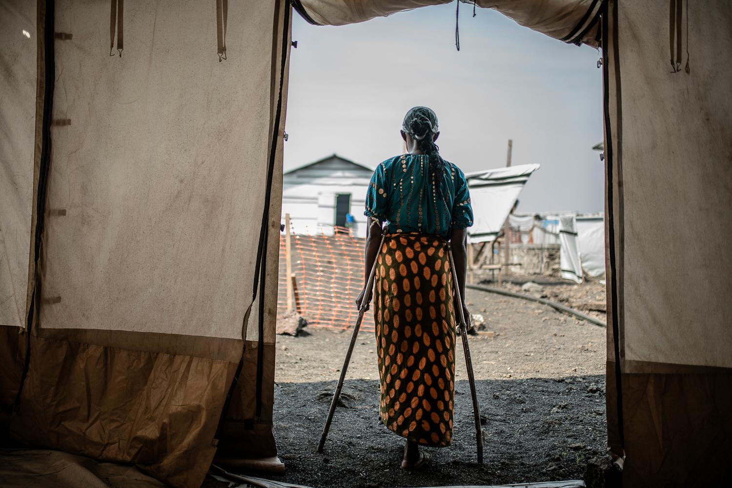 Una donna costretta a fuggire dalla violenza nel Congo orientale guarda le tende nel campo profughi di Bolingo, dove ora vive.  Nel 2023 un numero record di persone sarà costretto a fuggire a causa di conflitti e disastri umanitari in tutto il mondo. 