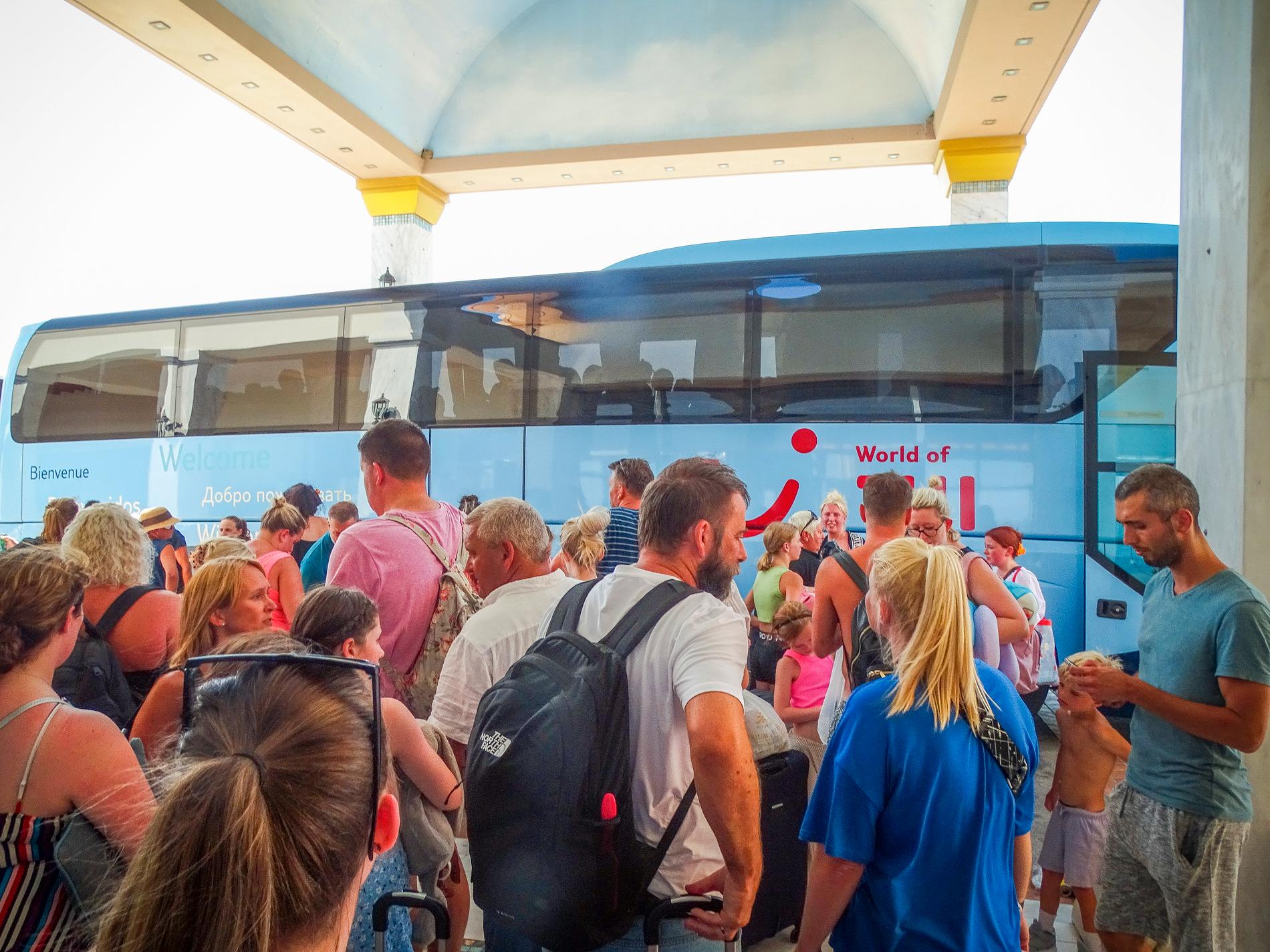 Turister venter på en buss som skal evakuere dem bort fra områder berørt av skogbrann på Rhodos. Det er uvisst om noen av de avbildede turistene er norske. 