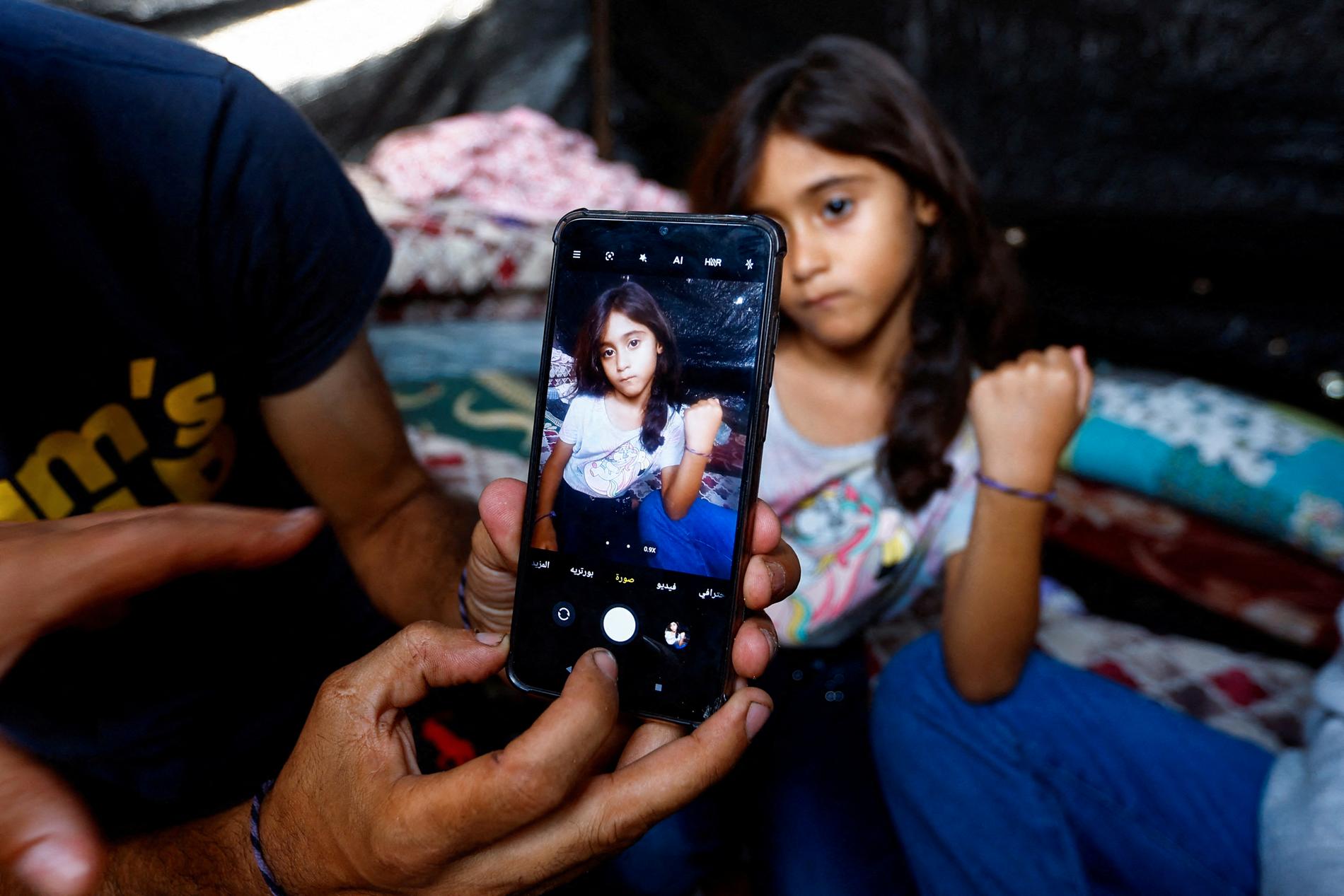 Tagging children: Palestinian Ali Daba in Gaza shows how he and his wife marked their children with bracelets for fear they would not be able to identify them if a family member was killed during Israeli air strikes.