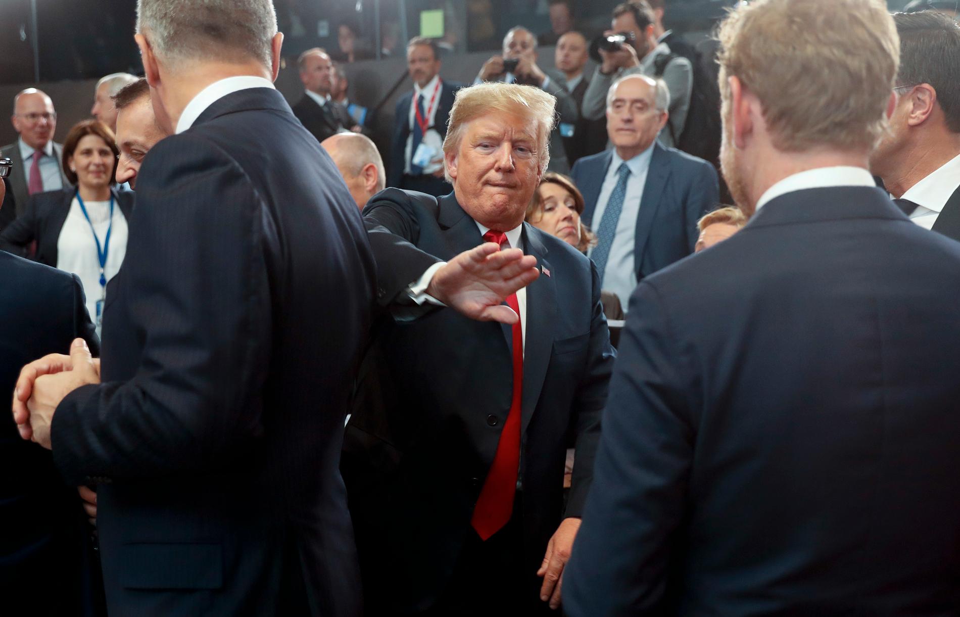 Out of the way: Donald Trump is making his way to a seat at the table at the 2018 NATO summit.